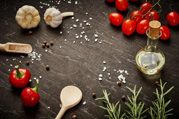 Siyah ahşap masa dökülen tuz ve sebze ve zeytin yağı ile