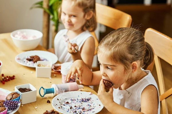 iki güzel kız kardeş beyaz elbise süslemeleri ve lezzetli kek yemek
