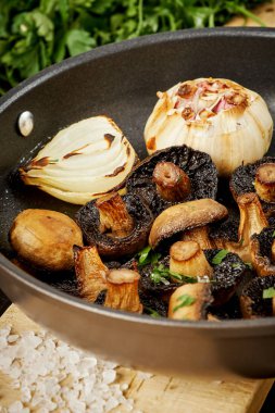 Eski bir ahşap masa üzerinde sıcak bir Pan kızarmış yağlı mantar