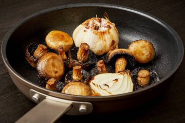 Eski bir ahşap masa üzerinde sıcak bir Pan kızarmış yağlı mantar