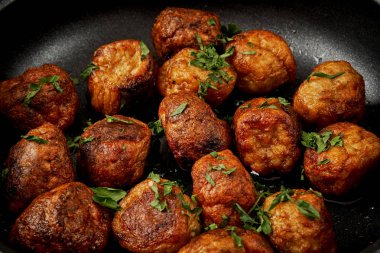 maydanoz siyah eski ahşap bir masa üzerinde bir tavada köfteyle