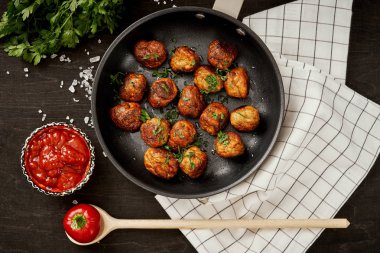 maydanoz siyah eski ahşap bir masa üzerinde bir tavada köfteyle