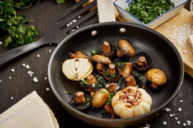 Eski bir ahşap masa üzerinde sıcak bir Pan kızarmış yağlı mantar