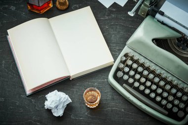 güzel eski gri daktilo, kitap ve bir bardak alkol ile