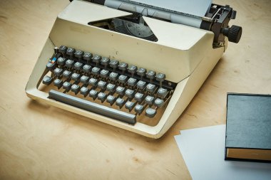 gri tuşları ve bir kitap ile parlak eski daktilo