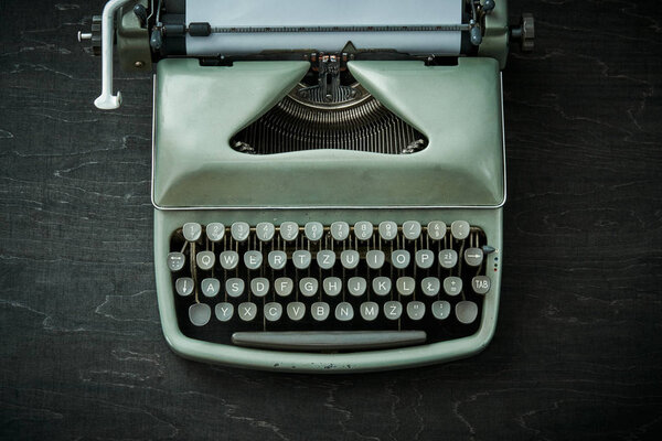 красивая серая пишущая машинка на черном столе
