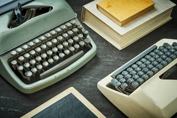 WO starých psacích strojů a knihu o černý stůl — Stock fotografie
