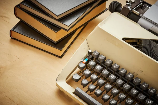Máquina de escrever velha brilhante com chaves cinzentas e livros — Fotografia de Stock