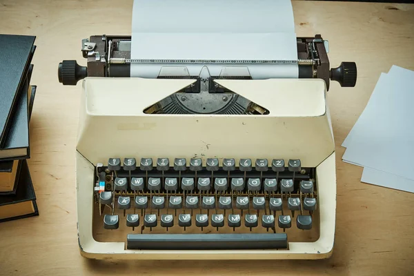 Ljusa gammal skrivmaskin med grå nycklar och böcker — Stockfoto