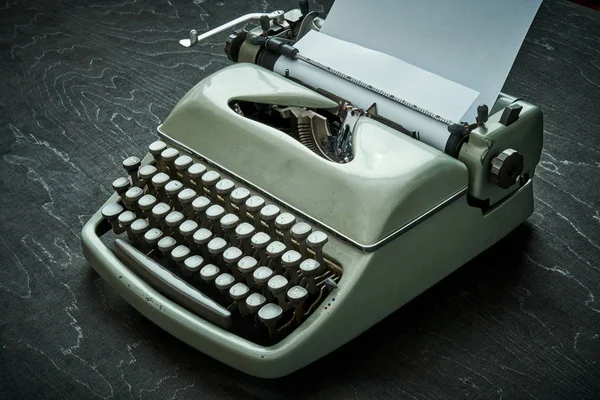 Bela velha máquina de escrever cinza em uma mesa preta — Fotografia de Stock