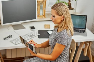 güzel sarışın kadın ofiste tablet çalışıyor