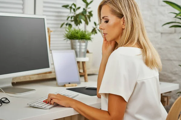 beautiful blonde woman working on the computer