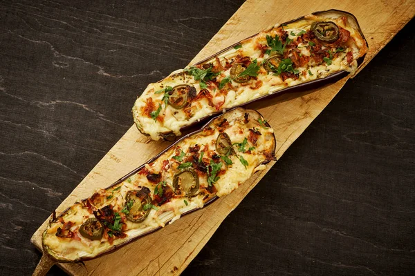 güveç patlıcan peynir ve jalapeno biber siyah bir tablo