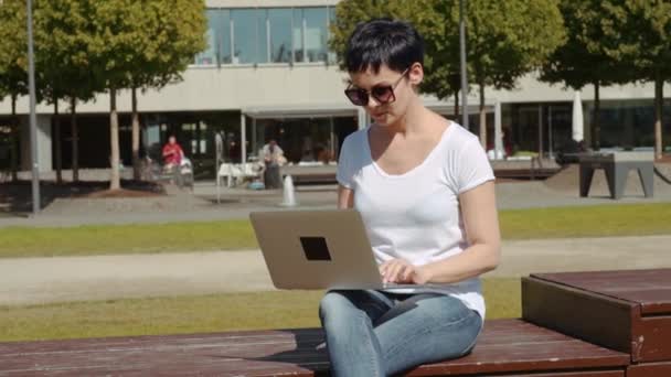 Obchodní žena sedí před kanceláří, budov a práci na počítači — Stock video