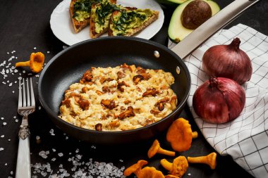 çırpılmış yumurta ile chanterelles düz gelen pan ve avokado ile ekmek ormanda