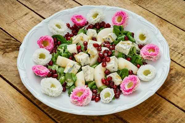 Kwiaty i pyszne sałatki z serem gorgonzola gruszki i sałata na białym talerzu — Zdjęcie stockowe
