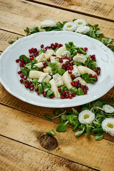 Kwiaty i pyszne sałatki z serem gorgonzola gruszki i sałata na białym talerzu — Zdjęcie stockowe