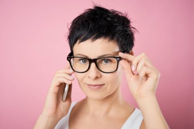 pembe bir arka plan telefonda konuşurken bardaklarda izole kadın