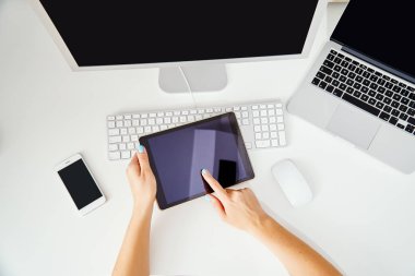 bir tablet ve bilgisayarlar tutan bir kadın ellerinde üstten görünüm