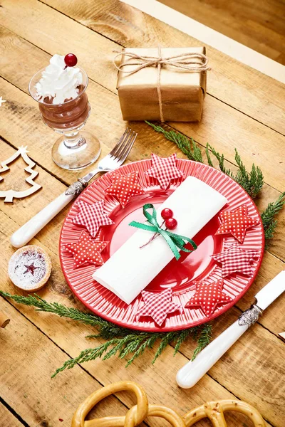 Christmas Eve background on an old wooden table with a red plate with a knife and fork — Stock Photo, Image