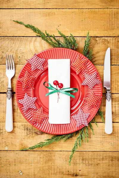 Christmas Eve background on an old wooden table with a red plate with a knife and fork — Stock Photo, Image