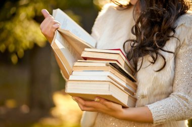 bir yığın kitap sonbahar bir orman arka planda tutan kadın