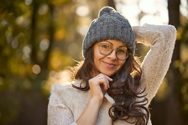 Красивая женщина в кепке и очках на фоне осеннего леса — стоковое фото