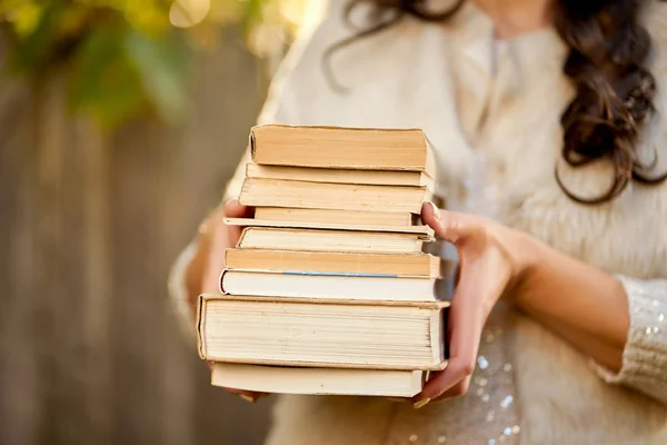 Femmes tenant une pile de livres avec une forêt d'automne en arrière-plan — Photo