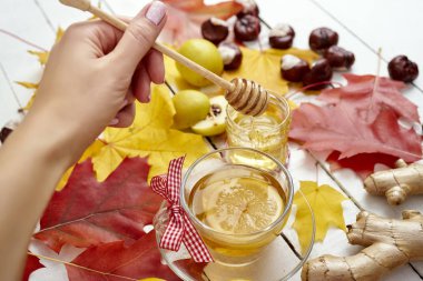 Hayatım için bir sopayla kadının el ve sonbahar ile ahşap bir tabloda Limonlu sıcak çay yaprakları
