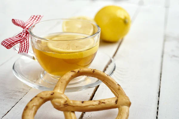 Delizioso tè caldo con miele e limone e pretzel su un vecchio tavolo di legno — Foto Stock