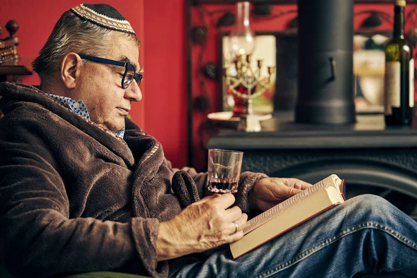 Judío senior leyendo un libro de la Torá y bebiendo vino kosher —  Fotos de Stock