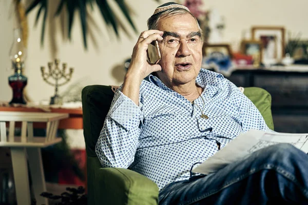Joodse senior praten aan de telefoon en het lezen van een boek van de torah — Stockfoto