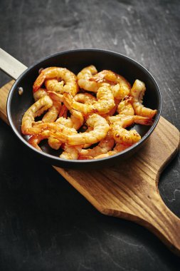 taze lezzetli kızarmış karides bir pan ve ahşap tahta