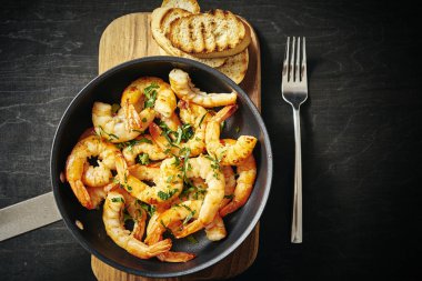 bir tava ve tost ahşap tahta üzerinde taze lezzetli kızarmış karides