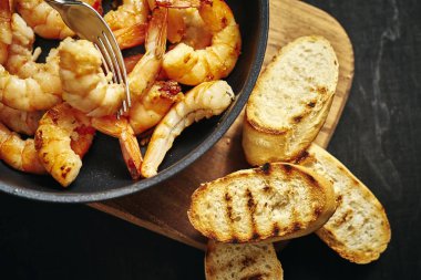 bir tava ve tost ahşap tahta üzerinde taze lezzetli kızarmış karides