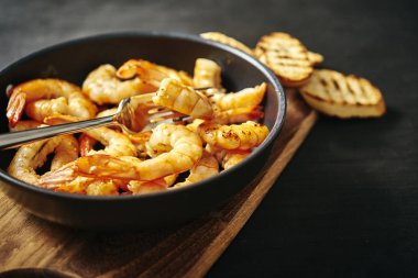 bir tava ve tost ahşap tahta üzerinde taze lezzetli kızarmış karides