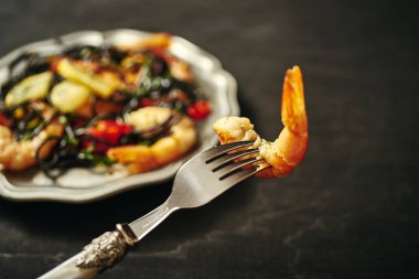 ızgara karides ve sebze, eski bir gümüş tepside lezzetli siyah spagetti çatalı