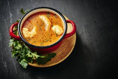 maydanoz ile kırmızı bir tencerede karidesli geleneksel Tay çorbası