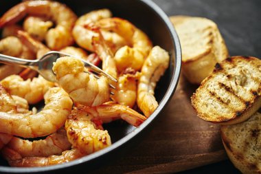 bir tava ve tost ahşap tahta üzerinde taze lezzetli kızarmış karides