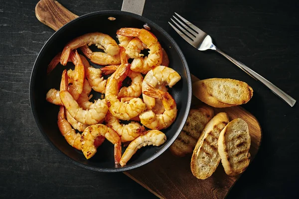 bir tava ve tost ahşap tahta üzerinde taze lezzetli kızarmış karides