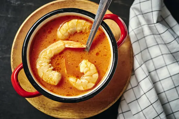 Zuppa tradizionale tailandese con gamberetti in una pentola rossa e un cucchiaio — Foto Stock