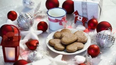 Gümüş hediyeler kırmızı kabarcıklar, ev yapımı kurabiye, kırmızı ışık ve süt ile parlak Noel dekorasyon