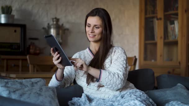 Beautiful Woman Sitting Couch Wrapped Blanket Uses Tablet — Stock Video