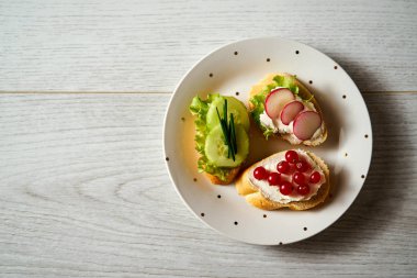plaka vejetaryen mini sandviç salatalık, turp ve Frenk soğanı ahşap bir masa üzerinde bir dizi