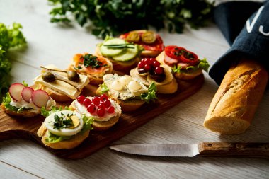 renkli mini sandviç ya da tapas bir bıçak baget ve maydanoz bir tablo ile birlikte kurula
