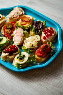 eski mavi tepsi sağlıklı tapas veya mini sandviç ahşap bir masa üzerinde bir dizi