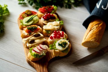 renkli mini sandviç ya da tapas bir bıçak baget ve maydanoz bir tablo ile birlikte kurula