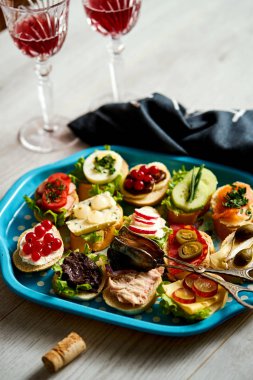 mini sandviç ya da tapas kümesi iki bardak şarap ahşap bir masa üzerinde