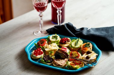 mini sandviç ya da tapas kümesi iki bardak şarap üzerinde ahşap masa lambası