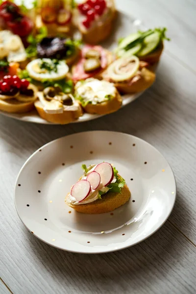 Plato con tapas coloridas y saludables y sándwich con queso y rábano en la mesa de madera —  Fotos de Stock